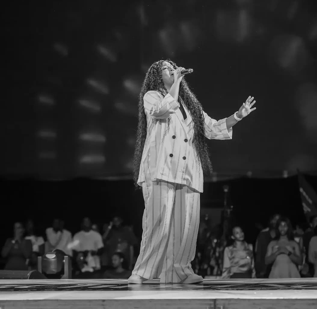 Black-and-white photograph of Bella Kombo performing at In Christ Now in Kigali, July 2026